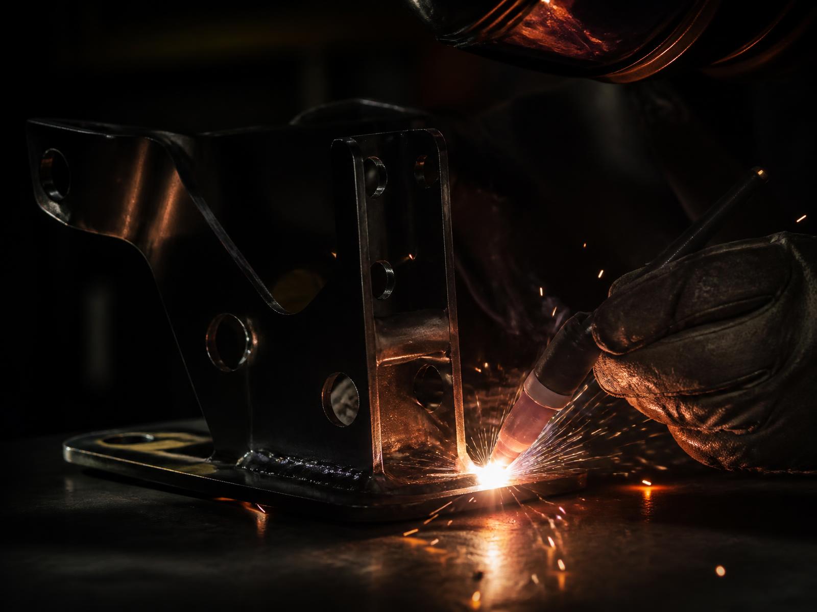 Welding a custom steel vehicle bracket in the workshop